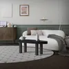 A living room scene with a sofa, coffee table, and rug. Produktbild-Vorschau