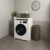 A laundry room with a washing machine and a cabinet. Voir les images du produit
