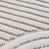 A close-up, angled view of a cream-colored rug with a textured, ribbed pattern. Voir les images du produit