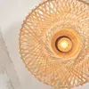 A close-up view of a woven bamboo lampshade with a light bulb visible in the center. Anteprima dell’immagine prodotto