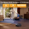 A couple is in a living room with a robot vacuum cleaner on the floor. The image highlights features of the robot vacuum. Produktbild-Vorschau