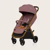 A pink baby stroller with gold accents is shown against a light beige background. Produktbild-Vorschau