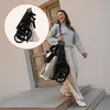 A woman walks down stairs carrying a folded stroller. Voir les images du produit