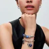 A close-up shot of a person's arm wearing two Pandora charm bracelets. Anteprima dell’immagine prodotto