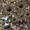 A garden drill and auger bit are shown on the ground next to several holes that have been drilled in the soil. Podgląd zdjęcia produktu