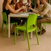 People enjoying drinks around a table with green chairs. Voir les images du produit