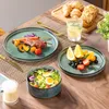 A table setting with plates of food, croissants, and a glass of water. Voir les images du produit