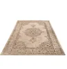 A beige oriental-style rug with an abstract pattern, shown from a slightly elevated angle on a white background. Voir les images du produit