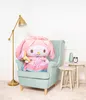 A large pink plush toy sits in a light blue armchair next to a floor lamp and small side tables. Voir les images du produit