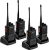 Four black walkie-talkies with orange accents are shown in their charging docks against a white background. Produktbild-Vorschau