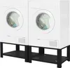 Two white washing machines are stacked on black metal stands. Náhľad obrázku produktu