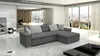 A modern living room with a large sectional sofa, a coffee table, and large windows overlooking a city. Náhled obrázku produktu