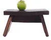 A green apple sits on a dark wooden stool against a white background. Produktbild-Vorschau