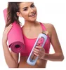 A woman is holding a yoga mat and a water bottle, suggesting a fitness context. Náhľad obrázku produktu