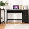 A black desk with a laptop, books, and photo frames on top, placed on a wooden floor with a rug. Produktbild-Vorschau