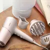 A Philips hair dryer and its accessories are arranged on a wooden surface. Produktbild-Vorschau