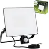 A black LED floodlight with a motion sensor is shown on a white background, with its packaging in the upper right corner. Náhled obrázku produktu
