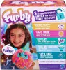 The image shows the packaging of a Furby toy, featuring a young girl holding the toy and text describing its features. Náhľad obrázku produktu