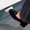 A foot in a black shoe pressing a silver pedal attached to a white surface. Voir les images du produit