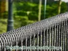 A close-up of a braided rope railing with a blurred green background. Náhľad obrázku produktu