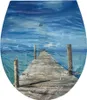 A wooden pier extending into a blue ocean under a cloudy sky. Produktbild-Vorschau