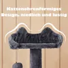 A close-up of a dark gray cat tree with cat ears on top, against a light brown wood-paneled background. Produktbild-Vorschau