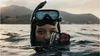 A person wearing a snorkel mask and holding a GoPro camera in the water. Voir les images du produit