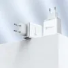 Two white USB wall chargers are displayed on a white surface against a light blue background. Anteprima dell’immagine prodotto