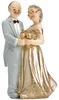 Figur eines älteren Ehepaares als Tortenaufsatz zur goldenen Hochzeit, Mann im hellen Anzug und Frau im goldenen Kleid stoßen mit Sektgläsern an. Anteprima dell’immagine prodotto