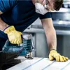 A person wearing safety gear is using a jigsaw to cut a piece of material. Voir les images du produit