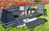 An outdoor seating set arranged on a lawn with flowers in the background. Produktbild-Vorschau
