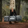 A person walking in a forest carrying a gray duffel bag with a logo. Produktbild-Vorschau