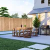An outdoor patio scene with a bamboo fence, dining set, and grill. Produktbild-Vorschau