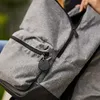 A person is holding a backpack with a black key locator attached to a zipper. Produktbild-Vorschau