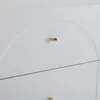 A close-up view of a white dresser or cabinet with gold knobs. Podgląd zdjęcia produktu