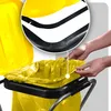 A close-up view of hands placing a yellow trash bag into a trash can holder. Anteprima dell’immagine prodotto