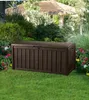 A brown storage box sits on a green lawn in a garden setting, with flowers and greenery in the background. Podgląd zdjęcia produktu