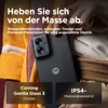 A person's hand is holding a dark gray smartphone, with the back of the phone and its camera module visible. The phone is partially tucked into clothing, suggesting a lifestyle context. Text overlays highlight product features. Náhled obrázku produktu