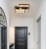 A hallway with a modern ceiling light, a black door, and a large mirror. Produktbild-Vorschau