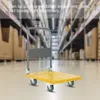 A yellow trolley is shown in a warehouse setting, with shelves of boxes in the background. Náhled obrázku produktu