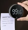 A hand holding a digital kitchen timer next to a breakfast menu. Podgląd zdjęcia produktu