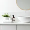 A clean and minimalist bathroom countertop with a sink, faucet, and various accessories. Anteprima dell’immagine prodotto