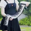 Person, die eine schwarz-weiße flexible Roll-up-Piano-Tastatur mit Bedientasten hält Voir les images du produit