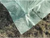 Close-up of the corner of a green greenhouse cover on the ground. Produktbild-Vorschau
