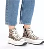 A pair of women's high-top sneakers with a leopard print pattern, worn with blue jeans. Produktbild-Vorschau
