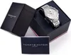 A Tommy Hilfiger watch is displayed in its open box, alongside its packaging and documentation. Produktbild-Vorschau