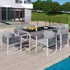 A patio dining set with chairs and a table is set up on a wooden deck next to a swimming pool. Produktbild-Vorschau
