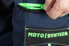 A close-up shot of a person's hand opening a zippered pocket on a pair of dark blue work pants. The pocket has a neon green zipper and a black patch with neon green text that reads "MOTO | SYNTEZA". Produktbild-Vorschau