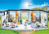 A Playmobil hospital playset with figures and medical equipment, set against a bright outdoor backdrop with a helicopter in the sky. Anteprima dell’immagine prodotto