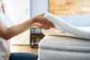 A person placing a mattress topper on a mattress. Náhľad obrázku produktu